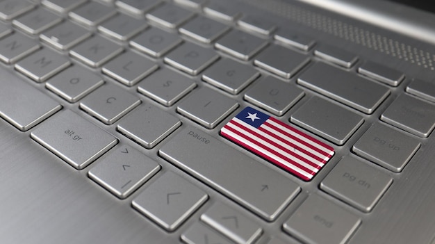 Foto la tastiera con la bandiera della liberia sul pulsante enter rappresenta la lingua di apprendimento degli attacchi informatici