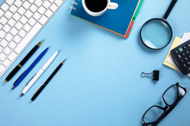 Photo keyboard with notepad and coffee with stationary on table