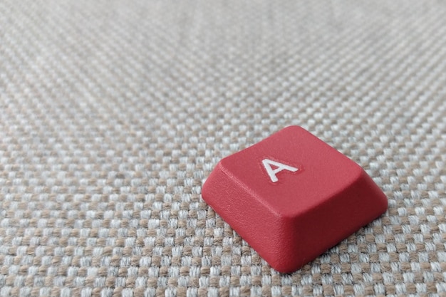 灰色の背景に赤い文字Aが描かれたキーボード