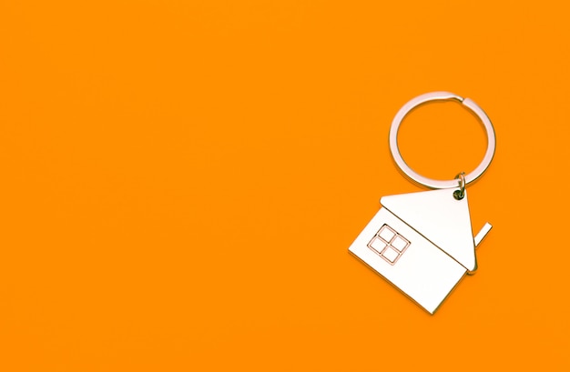 Keychain in the form of a house on a orange background