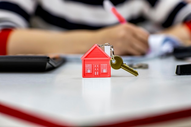 Keychain in the form of a house with a key on the table