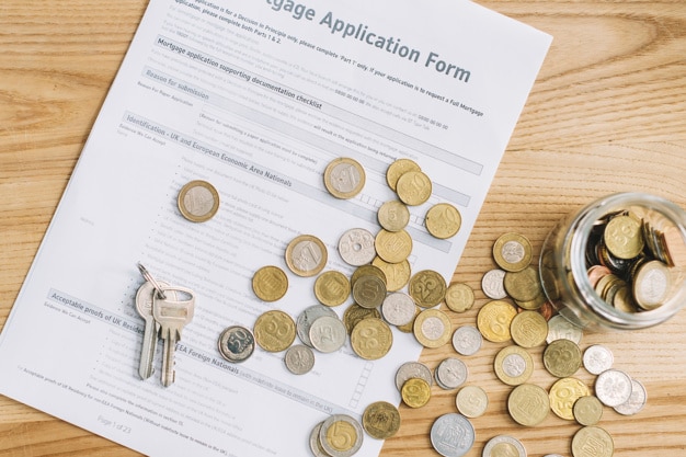 Photo keys and coins on mortgage application form