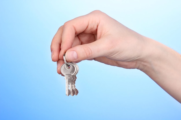 Keys in hand on blue background