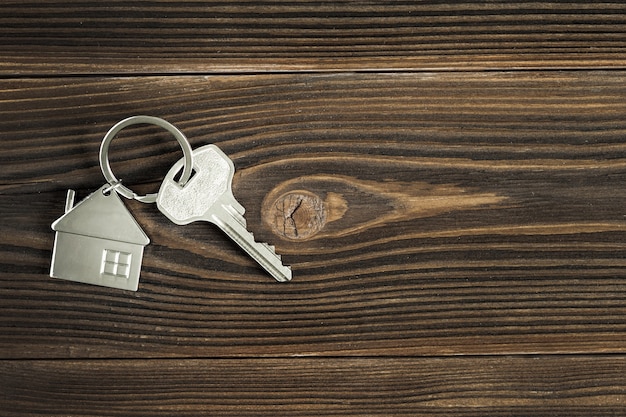 The keys to the house are on the wooden table top. The view from the top. The concept of buying a new home.