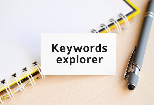 Keywords explorer - text on a notebook with a spring and a gray pen