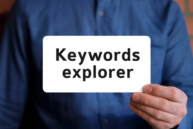 Keywords explorer - text on a white sign in the hand of a man in a blue shirt