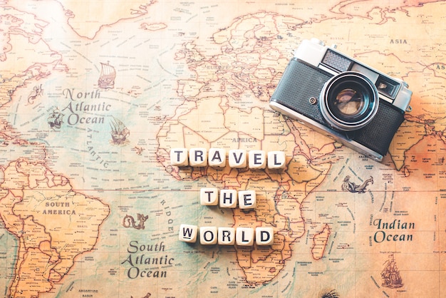 Keywords "TRAVEL THE WORLD" are on the world map. Tourism concept