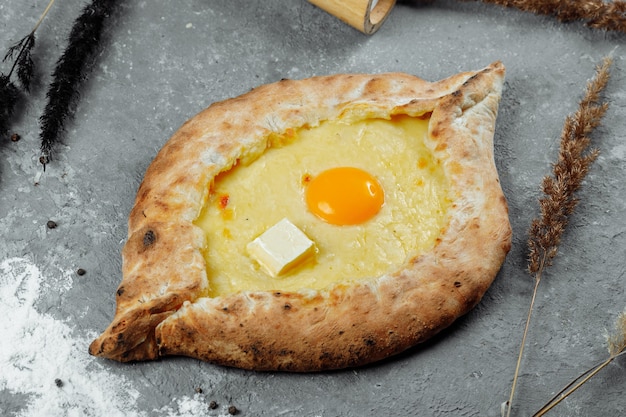 Khachapuri in Adjarian. Open pie with mozzarella and egg. Georgian cuisine