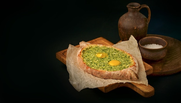 Khachapuri met ei op houten achtergrond in rustieke stijl Adjara Khachapuri met ingrediënten Georgische keuken