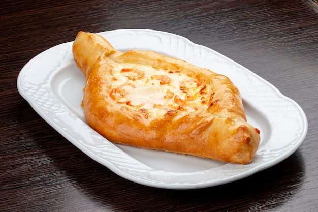 Khachapuri met garnalen en kaas op een houten achtergrond