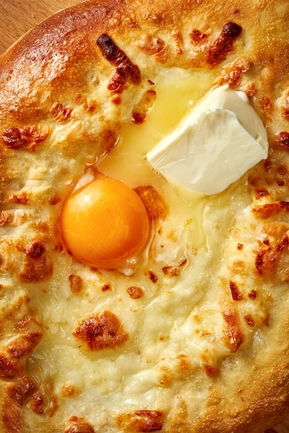 Khachapuri met zoute gesmolten kaas en eigeel in een plaat Concrete achtergrond