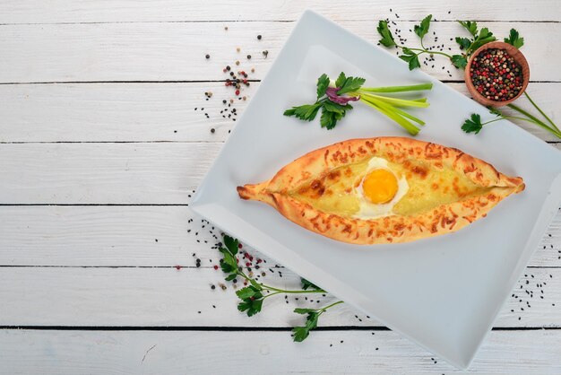 Khachapuri with egg and cheese Georgian cuisine Top view On a wooden background Copy space