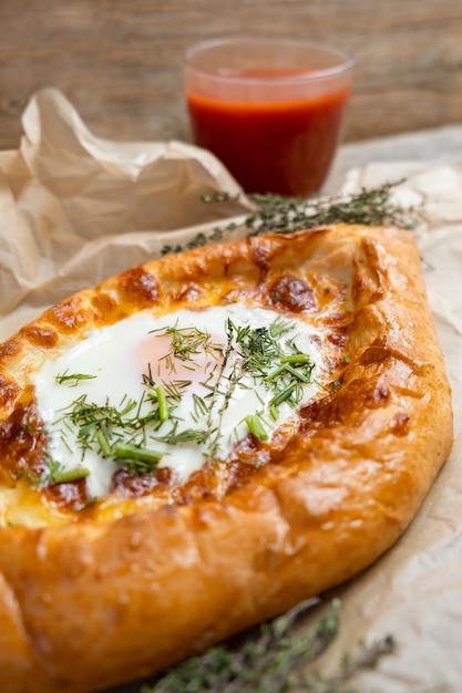 Khachapuri with the egg and herbs. Georgian cuisine.