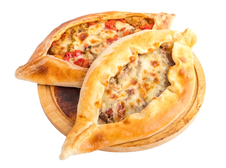 Photo khachapuri with vegetables and khachapuri with meat filling on a round wooden tray