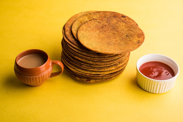 Khakhra or Khakra is a thin cracker is a popular Jain, Gujarati and Rajasthani  breakfast food. Served with Hot Tea and Tomato Ketchup. Over colourful or wooden background