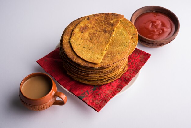 Foto khakhra of khakra is een dunne cracker en is een populair ontbijt voor jain, gujarati en rajasthani. geserveerd met hete thee en tomatenketchup. over kleurrijke of houten achtergrond