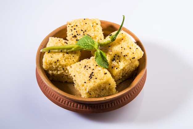 Khaman Dhokla is een vegetarische snack of ontbijtproduct uit de Indiase deelstaat Gujarat. geserveerd met gebakken groene chili