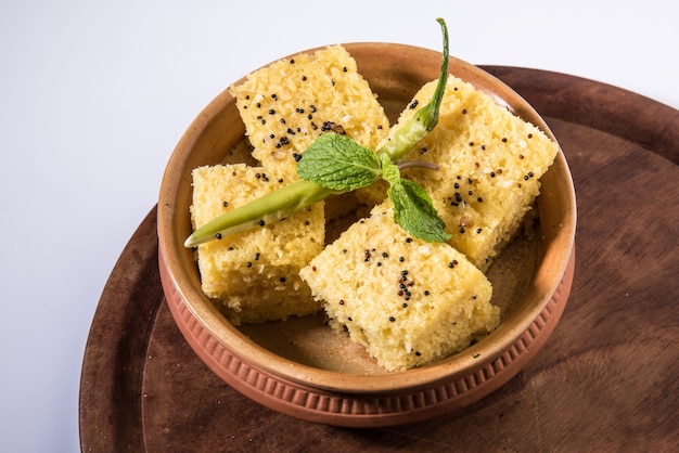 Foto khaman dhokla è uno spuntino vegetariano o un prodotto per la colazione proveniente dallo stato indiano del gujarat. servito con peperoncino verde fritto