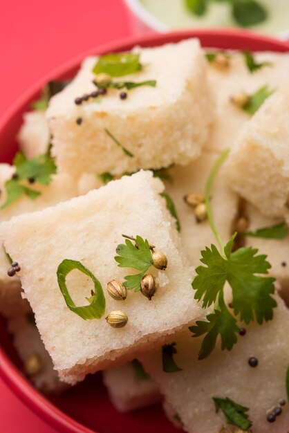 Khaman white Dhokla, состоящий из риса или урад-дал, - популярный рецепт завтрака или закусок из Гуджарата, Индия, который подается с зеленым чатни и горячим чаем. Выборочный фокус