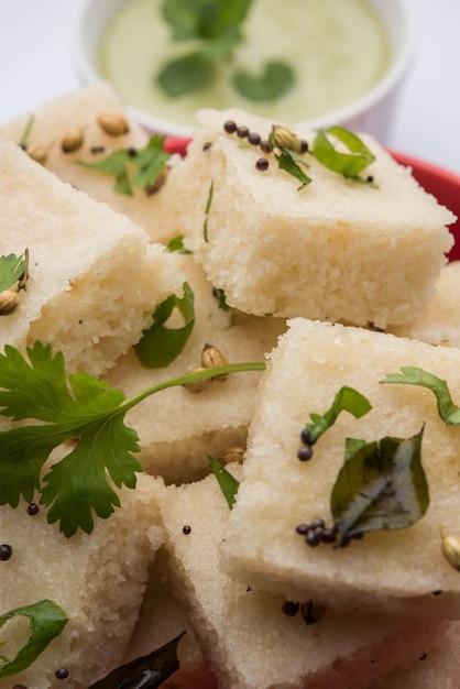 Khaman witte Dhokla bestaande uit rijst of urad dal is een populair ontbijt- of snackrecept uit Gujarat, India, geserveerd met groene chutney en hete thee. Selectieve focus