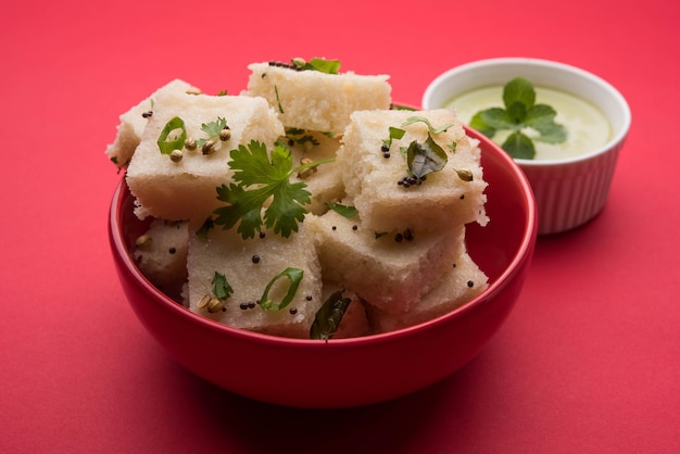 Khaman witte Dhokla bestaande uit rijst of urad dal is een populair ontbijt- of snackrecept uit Gujarat, India, geserveerd met groene chutney en hete thee. Selectieve focus