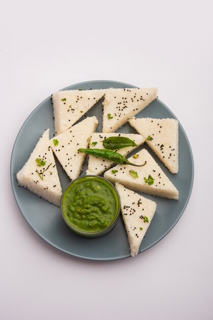 Khaman witte Dhokla bestaande uit rijst of urad dal is een populair recept voor ontbijt of snacks uit Gujrat, India, geserveerd met groene chutney en hete thee. Selectieve focus