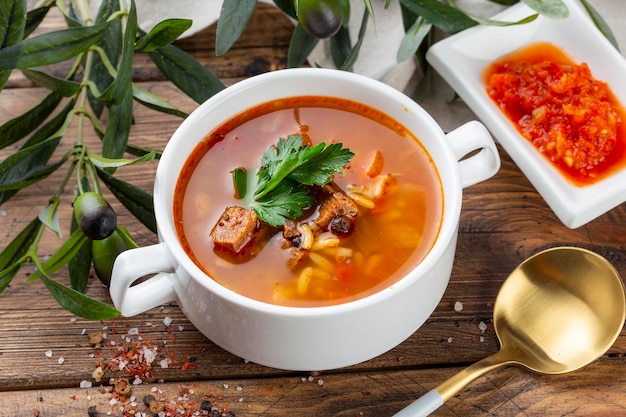 Kharcho soup with lamb meat rice tomatoes carrots peppers walnuts and spices Wooden background