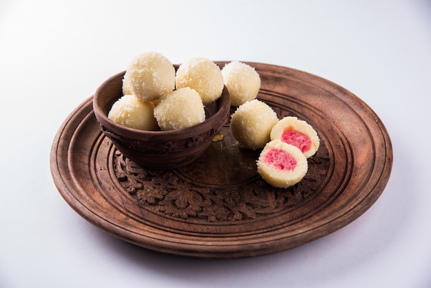 Kheer Kadam or Raskadam is a popular Bengali sweet or mithai especially prepared during festivals. Rassgulla is coated with roasted paneer,Khoya and coconut. Served in a bowl over moody background.