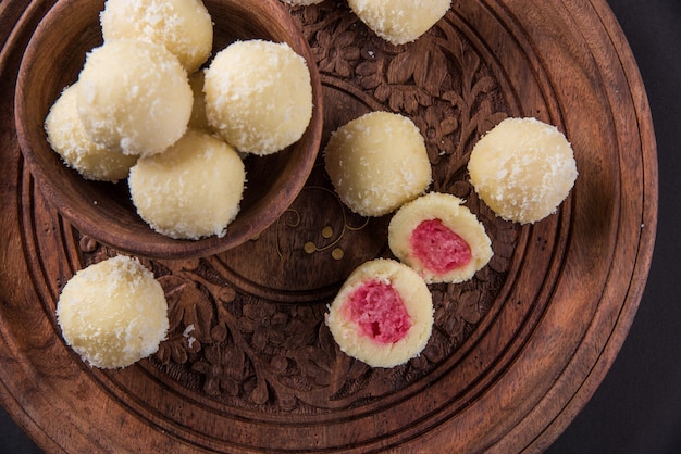 Kheer Kadam or Raskadam is a popular Bengali sweet or mithai especially prepared during festivals. Rassgulla is coated with roasted paneer,Khoya and coconut. Served in a bowl over moody background.