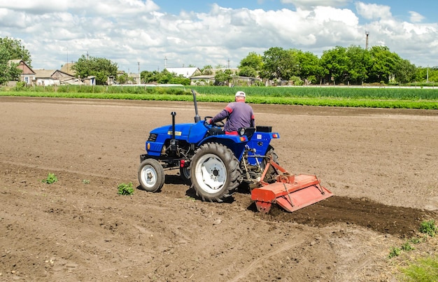 Kherson oblast Ukraine May 28 2020 A farmer on a tractor mills and cultivates an agricultural field Milling soil crushing and loosening ground before cutting rows Use of agricultural machinery