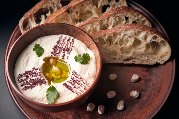 Khumus with bread on a clay plate