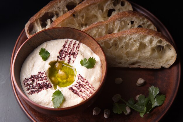 Khumus with bread on a clay plate