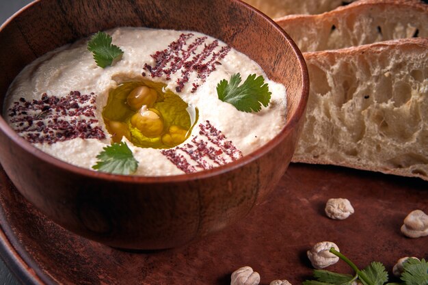 Khumus with bread on a clay plate