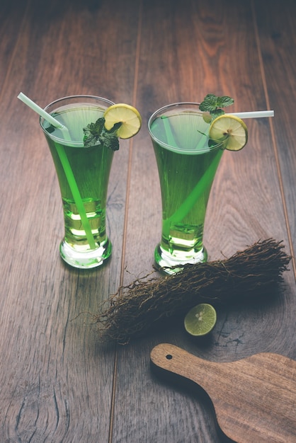 Khus sharbat or vetiver drink served in a glass with mint and lemon slice, selective focus