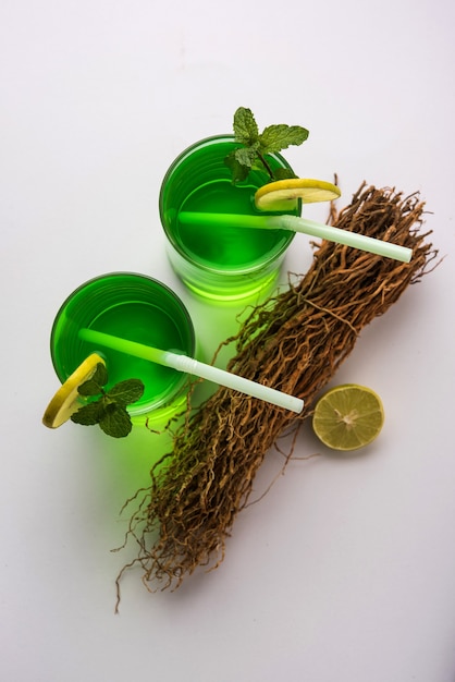Khus Sharbat or Vetiver Drink served in a glass with Mint and Lemon slice, selective focus