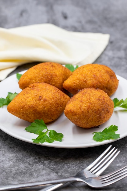 Photo kibbeh on a dark background kibbeh is a popular dish in middle eastern cuisine stuffed meatballs food falafel icli kofta quibe vertical view close up