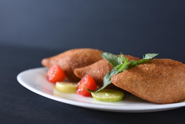 Photo kibbeh, a form of the arabic word kubbah or ball, is a staple in middle eastern cuisine. made out