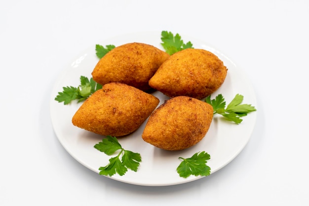 Киббе на белом фоне Киббе - популярное блюдо в ближневосточной кухне Набитые мясные шарики Еда Фалафель икли Кофта Куибе Горизонтальный вид Вблизи