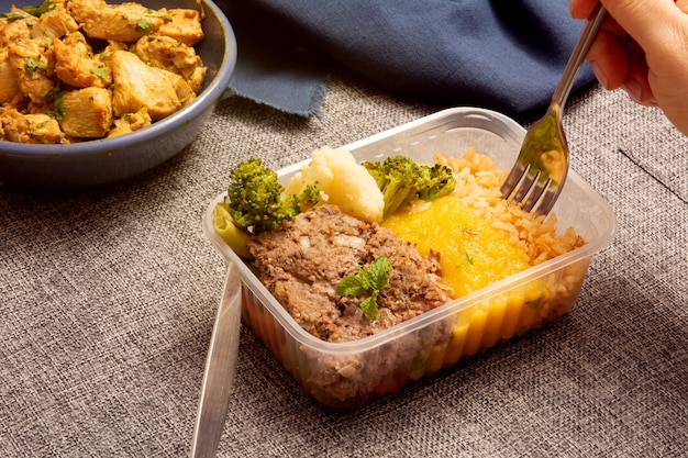 Photo kibe healthy packed lunch box being eaten with fork and knife in aerial view