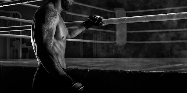 Фото Кикбоксер держится за канат на ринге спортивные соревнования бой