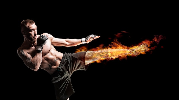 Kickboxer in posa sul ring. middle kick con un piede in fiamme. il concetto di mma, wrestling, muay thai. tecnica mista