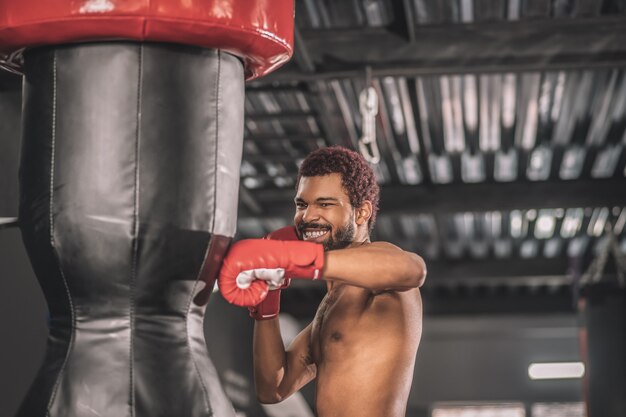 킥 복서. 체육관에서 운동을하는 젊은 어두운 피부의 kickboxer