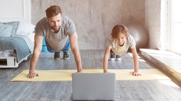 写真 子供と彼の父親は家でスポーツをしています