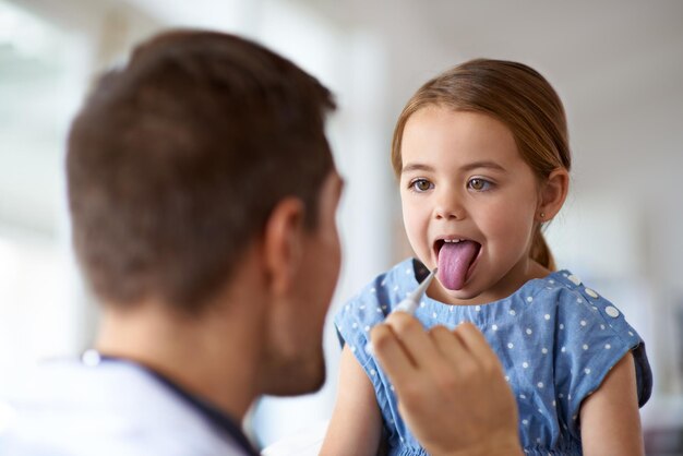 Kid-arts en thermometer in de mond in het ziekenhuis van medisch risico covid-infectie en koorts Kinderarts ziek meisje en testtemperatuur van kindergriepvirus en gezondheidszorgadvies in kliniek