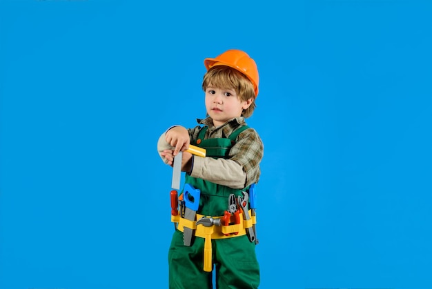 Kid as construction worker builder little boy in helmet and tools little boy plays construction