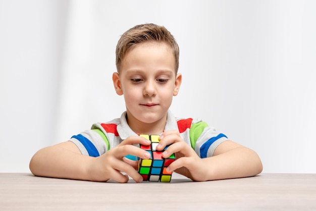 Kid assembles a rubik cube Concept of hobby play and solving puzzles Closeup