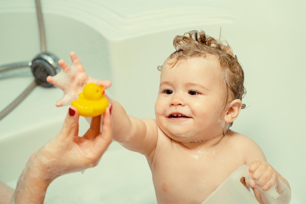 Kid bathing in bathtub funny happy baby bathes in bathtub with water and foam kids hygiene smiling k