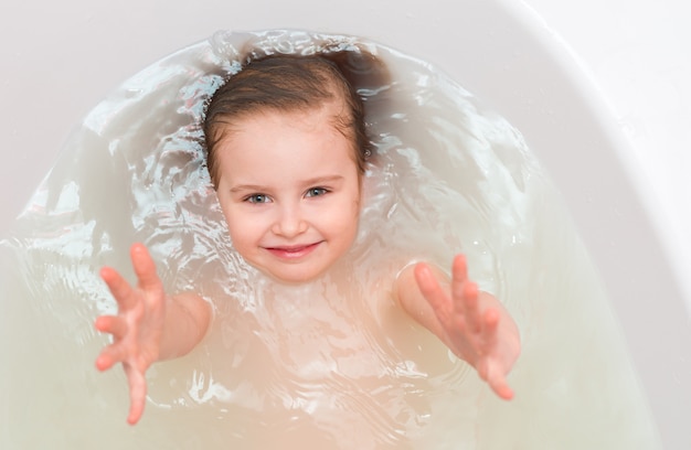 Kid in a bathtub, reaching out, topshot