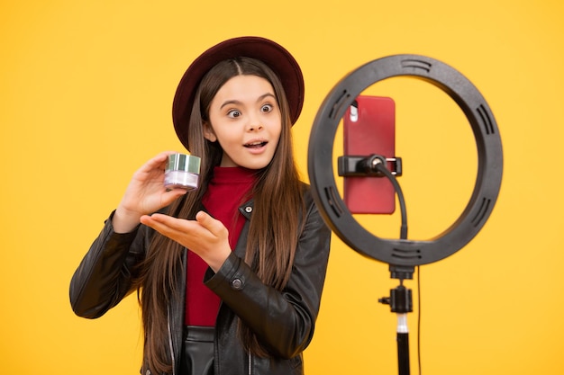 Kid beauty blogger vrolijk kind make-up vlogger met cosmetica maken video blog op telefoon bloggen ring lamp weblog en vlog make-up tutorial influencer verbaasd tiener meisje gebruik selfie led