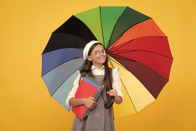 Kid in beret with rainbow umbrella autumn season rainy weather forecast back to school